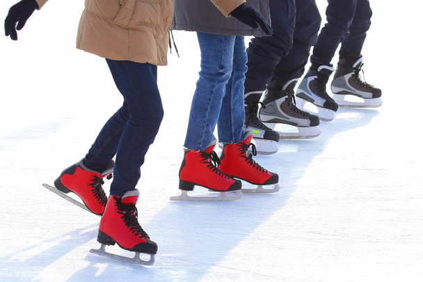 feet of different people skating on the ice rink - Foto, imagen