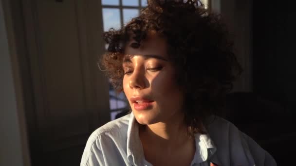 Beautiful girl with curly brown hair in the sun. Close up - Imágenes, Vídeo