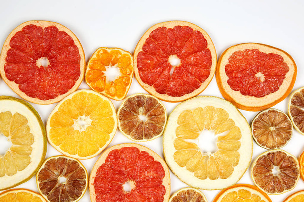 Dried slices of various citrus fruits on white background - 写真・画像