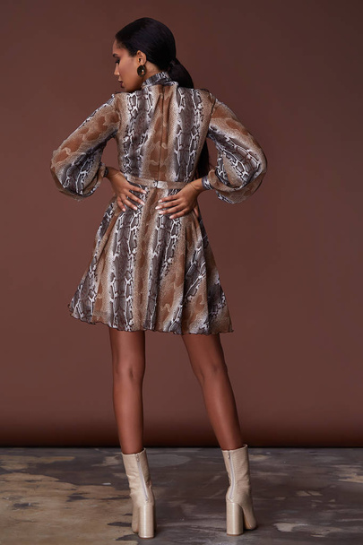 Sexy beauty woman pretty face tan skin wear animal print silk dress long skinny body shape makeup cosmetic spring collection studio catalog curly hair clothes for date meeting walk party style. - 写真・画像