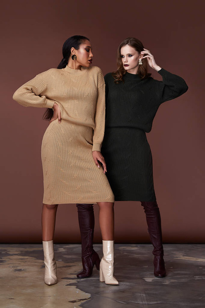 Two sexy beauty women pretty face wear beige and green knitted suit  body shape makeup cosmetic accessory bag collection shoes studio catalog brunette clothes for office casual dress code fashion. - Φωτογραφία, εικόνα