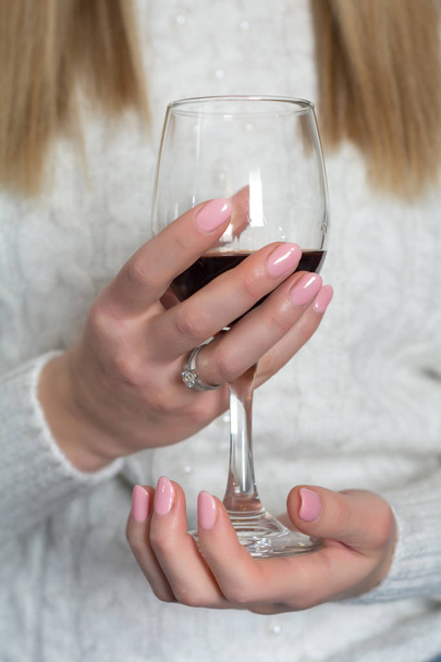 Młoda dziewczyna z baby różowy kolor paznokci Polski żel trzyma kieliszek do wina. Pojęcie manicure i kosmetycznych. Zbliżenie, Selektywny fokus - Zdjęcie, obraz