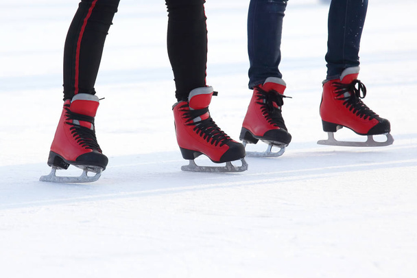 feet in red skates on an ice rin - Foto, Imagen