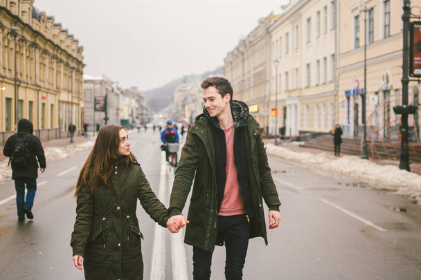 young couple, heterosexual boy and girl of Caucasian nationality, loving couple, walk around the center of country of European city in the middle of road on divided lane. Love and Romance Theme. - Photo, Image