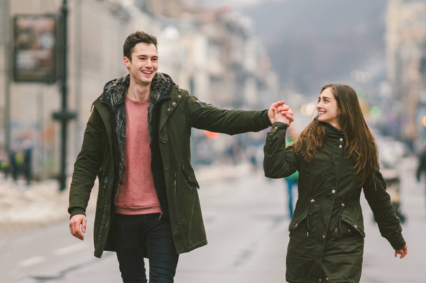 young couple, heterosexual boy and girl of Caucasian nationality, loving couple, walk around the center of country of European city in the middle of road on divided lane. Love and Romance Theme. - Foto, imagen