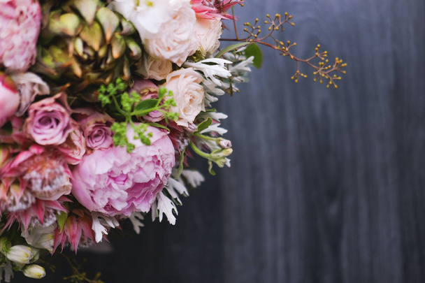 Big beautiful wedding bouquet of spring  flowers on wooden background. Peonies, roses, tulips, grass. Wedding concept. - Foto, Bild