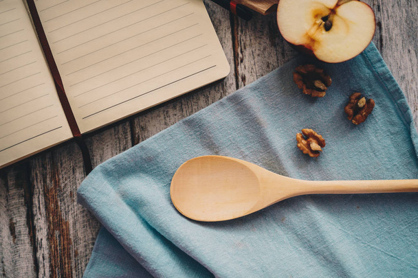 Cooking a recipe book with apple walnuts and spoon on wooden and - 写真・画像