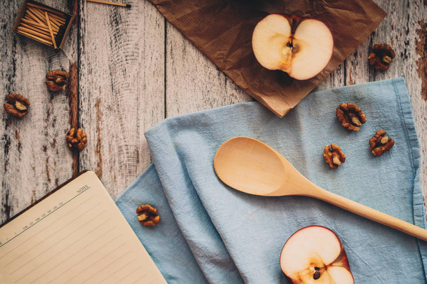 Cooking a recipe book with apple walnuts and spoon on wooden and - Foto, imagen