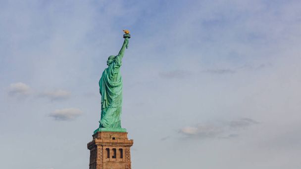 Vista de la Estatua de la Libertad contra el cielo y las nubes, en Nueva York, EE.UU.
 - Foto, imagen