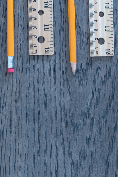 Pencils and rulers on gray wood grain background flat lay arrangement - Photo, Image