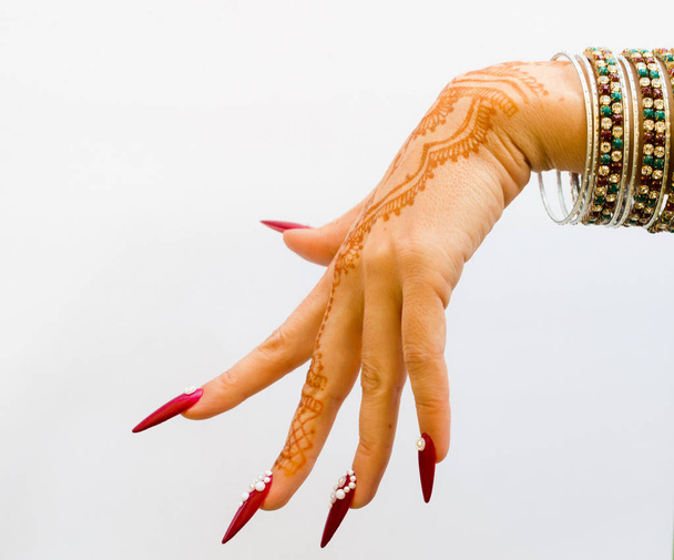 hand with henna tattoo, nails decorated with brilliants and bracelets with precious stones - Photo, Image