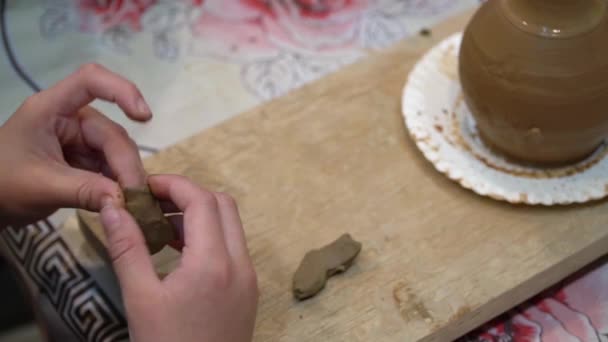 Child in the process of decorating the clay pot. Childrens pottery studio - Footage, Video
