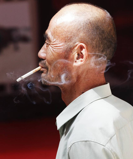 中国人男性が中国中部湖北省の公共の場所でタバコを吸う(2013年9月15日) - 写真・画像