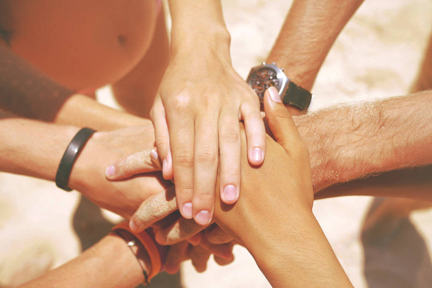 Group of Mixed Race Hipster Friends on the Beach with their Hands Stacked. Arms of Young People with on Stack. Lifestyle Team Building Concept. Thailand. - Photo, Image