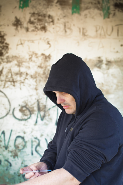 ναρκωτικών εξαρτημένος άνθρωπος με σύριγγα στα χέρια σε φόντο τοίχο - Φωτογραφία, εικόνα