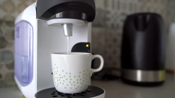 Kaffeemaschine für zu Hause bereitet eine Tasse frischen Kaffee mit Milch zu - Filmmaterial, Video