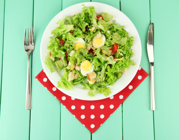 Caesar salad on white plate, on color wooden background - Fotografie, Obrázek