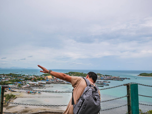 Asisn Fat Backpacker stand on top of Khao Ma Jor Pier with Idyllic ocean beautiful white cloud endless horizon and Fishman townscape in holiday time, chonburi thvania, holiday concept
 - Foto, Imagem