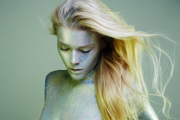 bright iridescent girl. Beautiful Young Woman with Sparkles on her Face and Body. Art Make-Up, in colorful light.  - Foto, imagen