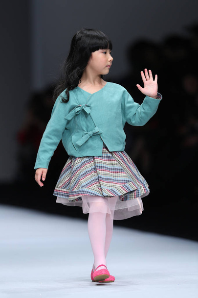 Um modelo jovem exibe uma nova criação no desfile de moda Kelkel durante a Shanghai Fashion Week Spring / Summer 2014 em Xangai, China, 20 de outubro de 2013
. - Foto, Imagem