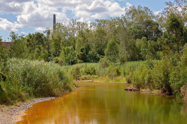 Egy kis patak vízzel elszíneződött ásványi szennyeződések közeli elhagyott arany bánya - Fotó, kép