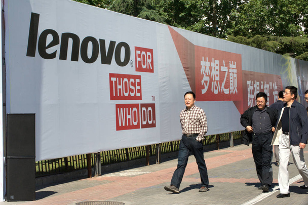 Los visitantes caminan más allá de un anuncio de Lenovo durante el PT / EXPO COMM China 2013 en Beijing, China, 24 Septiembre 2013
.  - Foto, imagen