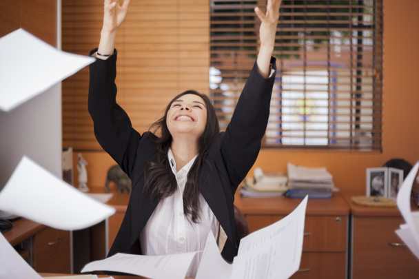 Young woman and flying papers in office - Photo, Image