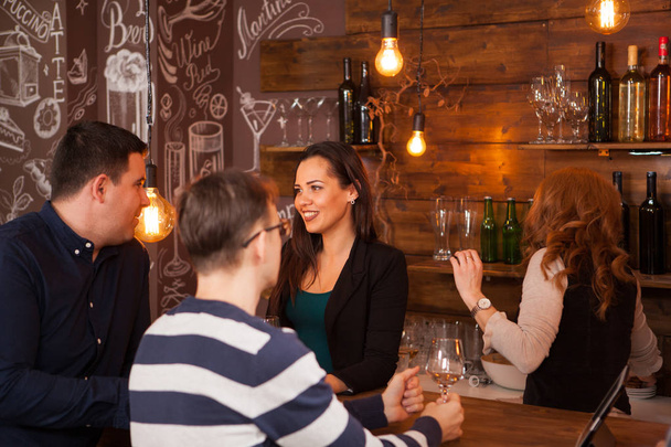 Happy vrienden interactie op toog in een pub - Foto, afbeelding