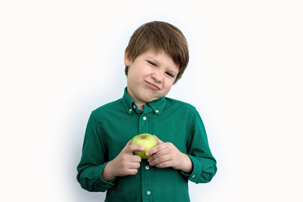 Junge hält grünen Apfel in der Hand, Emotionen - Foto, Bild