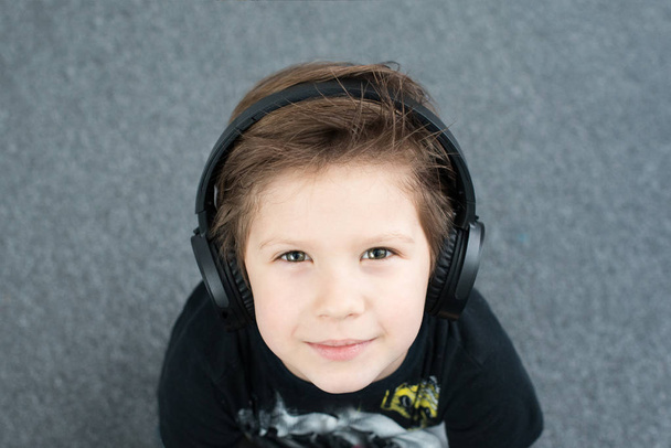 gyönyörű fiú fejhallgató, fiú 5 éves, zenét hallgatni. - Fotó, kép