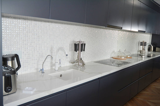 moderne Küche mit Mosaikfliesen, Wasserhahn, Dunstabzugshaube, Spiegel, Backofen. - Foto, Bild