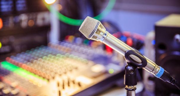 Metal microphone in the studio, cables and buttons in the blurry background - Foto, Imagen