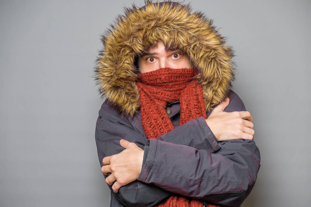 Studio portrait of man feeling cold and wearing warm clothes - Photo, Image