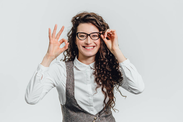 Komik gözlük güneş gözlüğü heyecanlı bir kadın portresi. Bir genç profesyonel iş kadını portresi Close-up ifade izole beyaz zemin üzerine komik bir surat yapar.. - Fotoğraf, Görsel