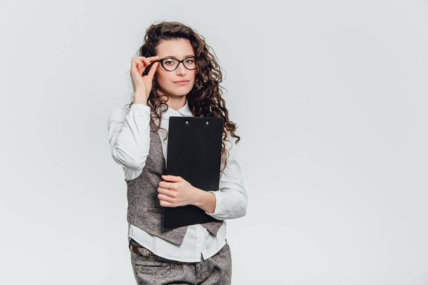 Happy beautiful young business woman standing. Holding clipboard over white background . - Foto, Imagen