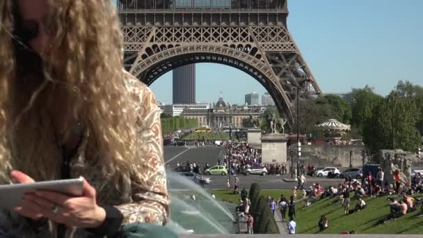 Mooie vrouw met haar in de wind vangt momenten en herinneringen in de buurt van de Eiffeltoren - Video