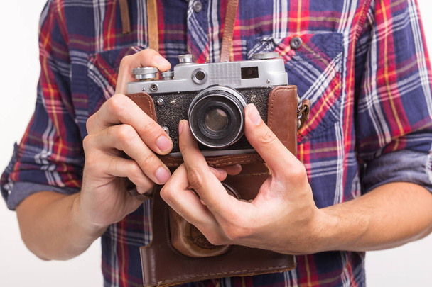 Vintage, photographer and hobby concept - close up of retro camera in mans hands over the white background - Фото, зображення