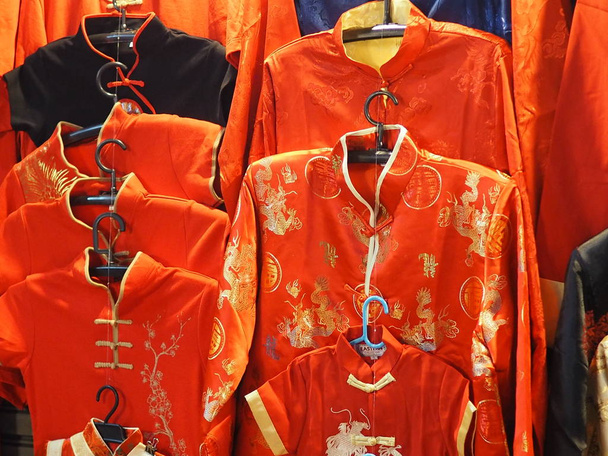Κόκκινο πουκάμισο που φοράει φόρεμα κινέζικο νέο έτος Cheongsam μανταρίνι - Φωτογραφία, εικόνα