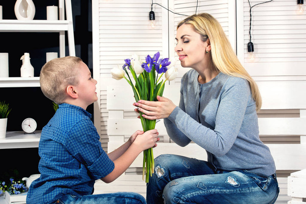 Son congratulates his beloved mother and gives her a bouquet of tulips.The concept of the celebration,woman's day.Mother's Day. - Photo, image
