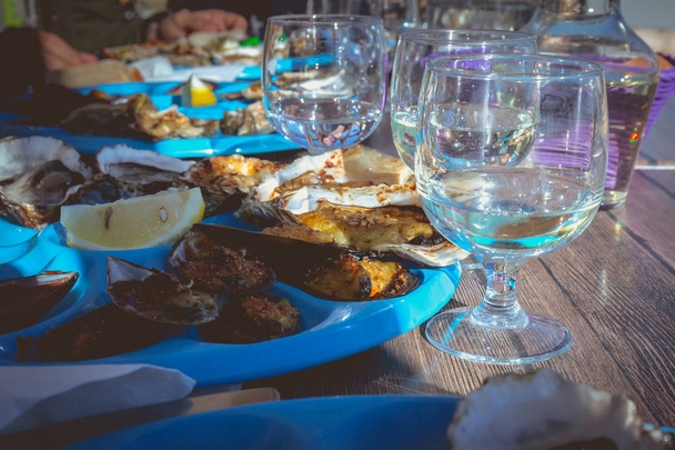 Gericht aus Austern und Muscheln gekocht und roh auf einem Tisch in der Nähe des Meeres in Südfrankreich - Foto, Bild