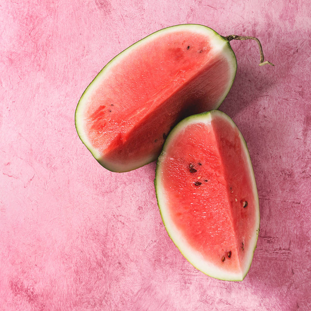 Ripe sliced watermelon over pink texture background. Flat lay, space. Square image - Foto, afbeelding