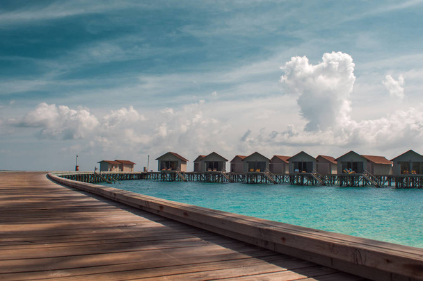 Bungalov tropikal doğa şaşırtıcı suda stilts. Maldivler resort - Fotoğraf, Görsel
