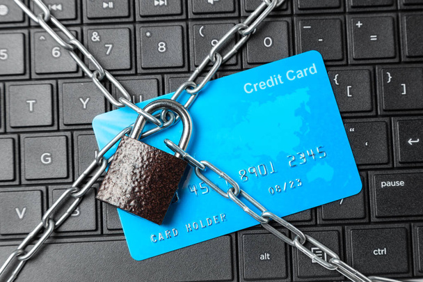 Credit card in chain with lock on laptop keyboard. Ban online payments and purchases in the online store - Photo, Image