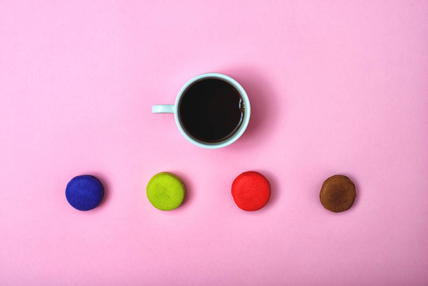 Colorful sweet macaroons and a cup of tea. Delicious breakfast. Top view. - Фото, изображение