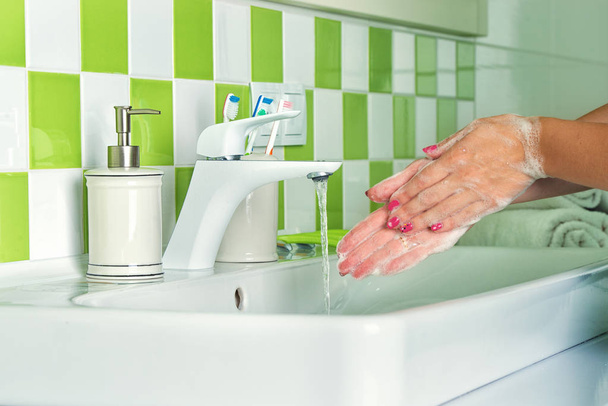 バスルームで石鹸で手を洗う女性. - 写真・画像