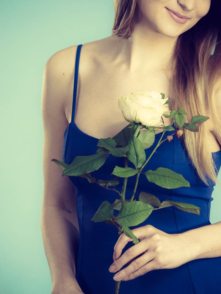 Young woman holding white rose flower in hand. Valentines and womens day, gift concept. - Foto, immagini