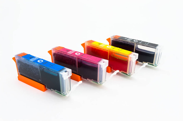 Close-up shot van een CMYK-inktcartridges voor een kleurenprinter geïsoleerd op een witte achtergrond met uitknippad. - Foto, afbeelding