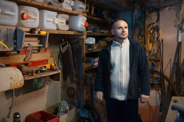 Portrait of pensive adult man in his workshop room - Photo, Image
