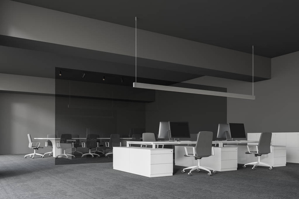 Szürke falak és a padló, nyitott tér területe fehér számítógépes asztalok és szürke székekkel és konferencia terem üvegfal mögött modern iroda sarkában. 3D-leképezés - Fotó, kép