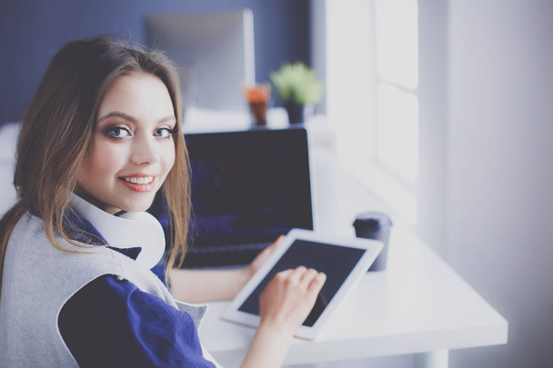 Young confident businesswoman working at office desk and typing with a laptop - Fotó, kép